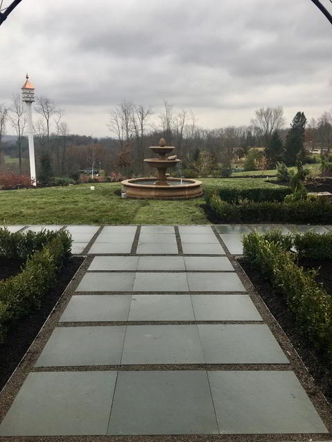 Hardscaping by garden leading to fountain.